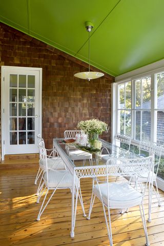 dining table on a back porch with a green ceiling