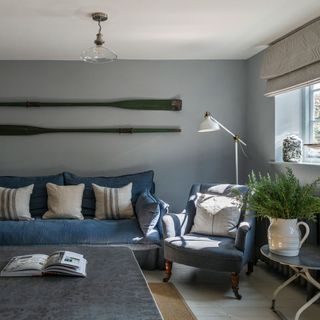 Living room with blue sofa set and cushions and white floor lamp