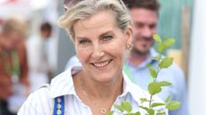 Duchess Sophie, wearing a striped dress, holds a plant as she attends the Groundswell Regenerative Agriculture Festival