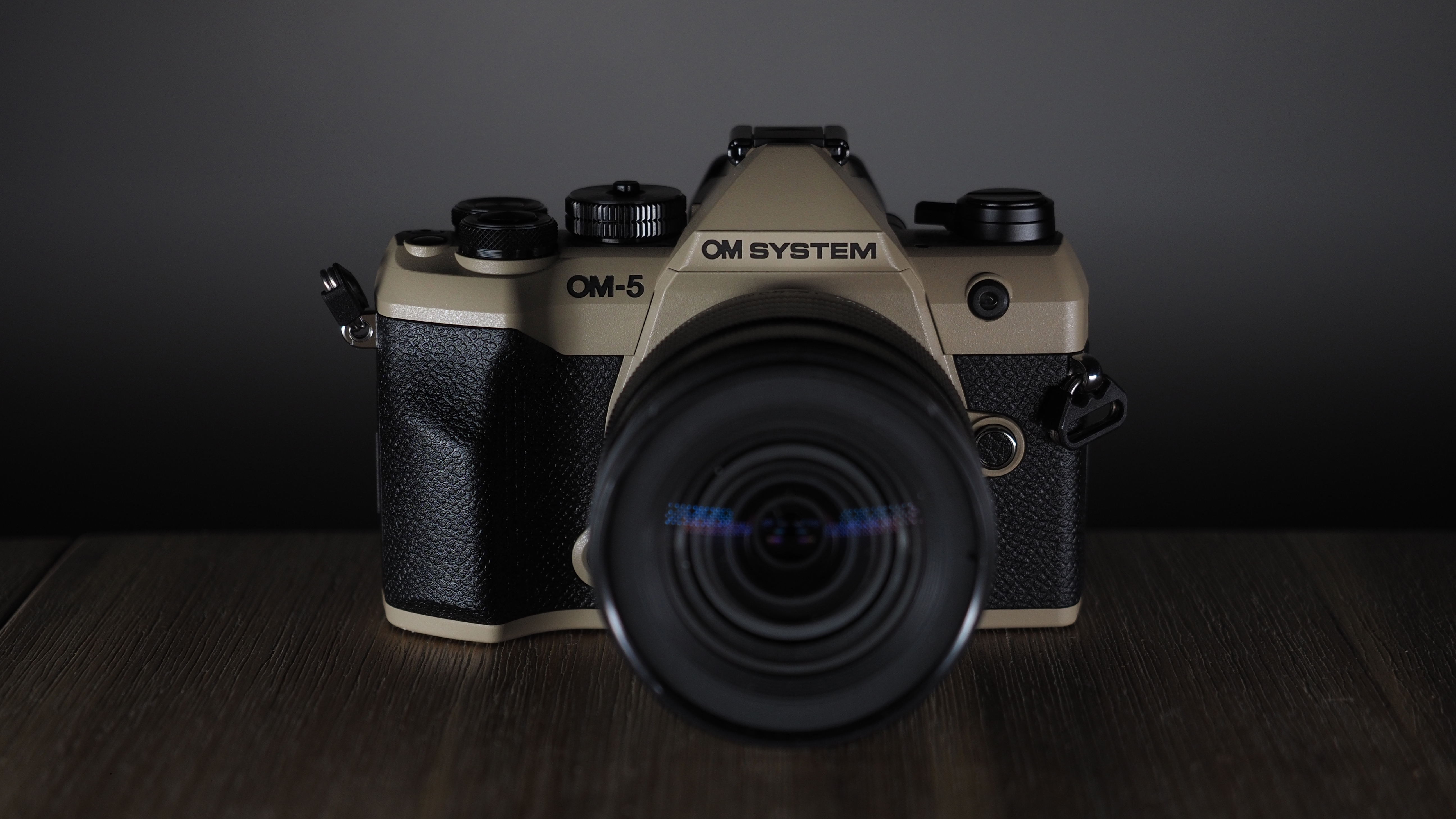 OM System OM-5 Mark II on a wooden surface with an Olympus M.Zuiko 12-45mm lens