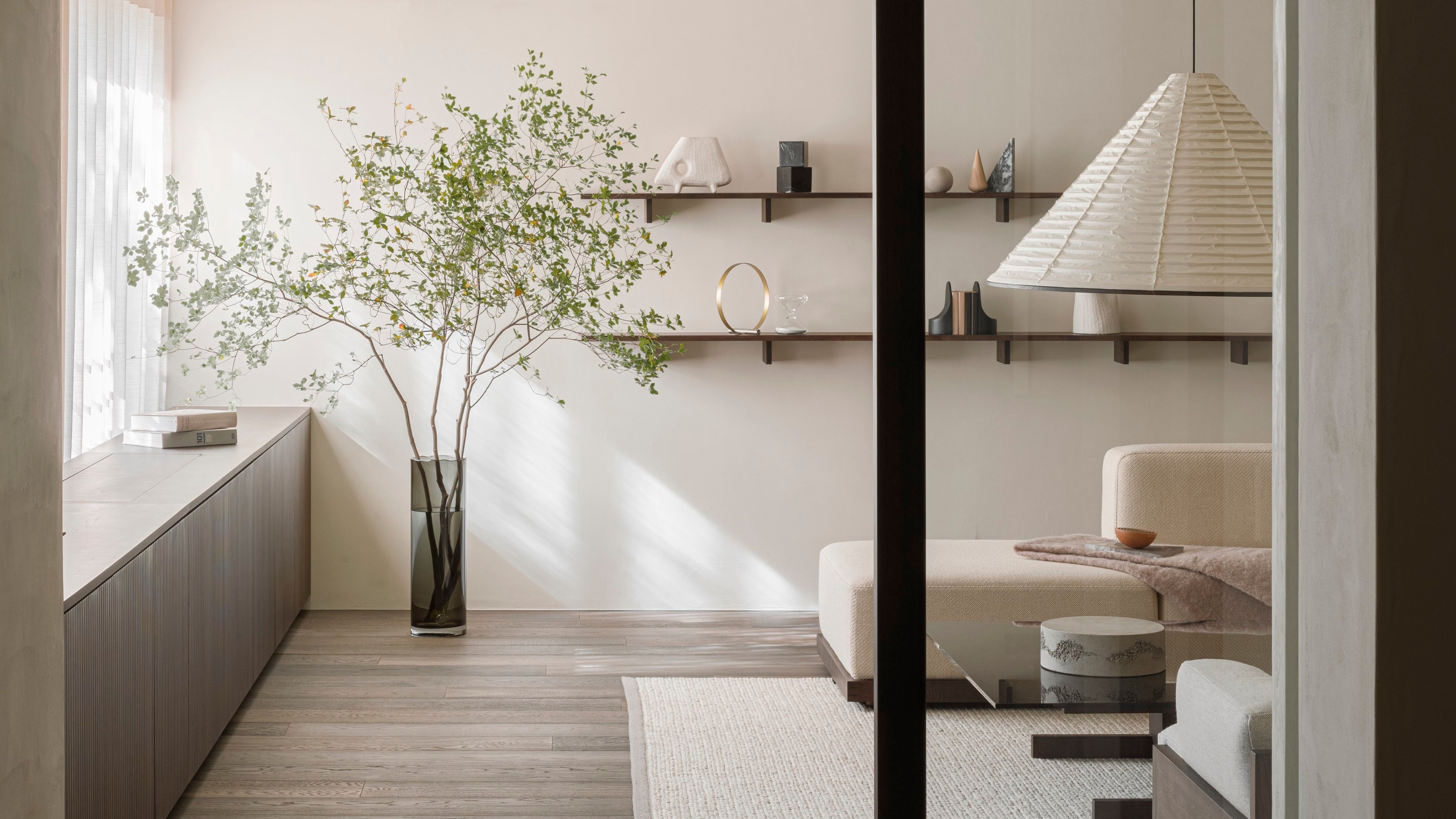 a living room in a japandi style with an oversized japanese style pendant light
