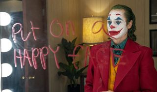 Joker staring at the message on his mirror, angered