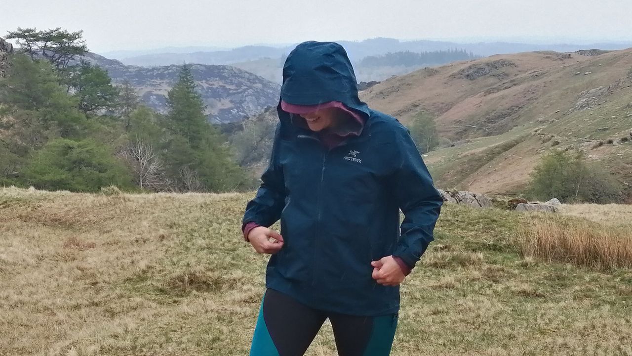 Waterproof vs water-resistant jackets: Woman wearing Arc&#039;teryx Beta jacket on a mountainside, in the rain