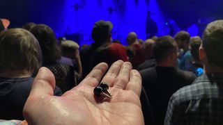 Flare Audio Isolate Pro earplugs on a man's hand in a music venue
