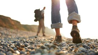 Image of two people wearing walking shoes on beach