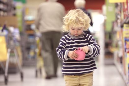 Toddler looking in purse in shop