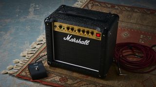 A Marshall DSL1CR tube amp on a rug with footswitch and guitar cable