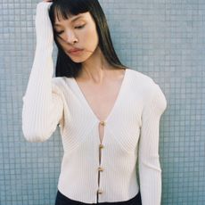Model wearing a white blouse sold at net-a-porter