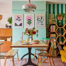 Colourful dining area with wooden table and bench and honeycomb-style shelves