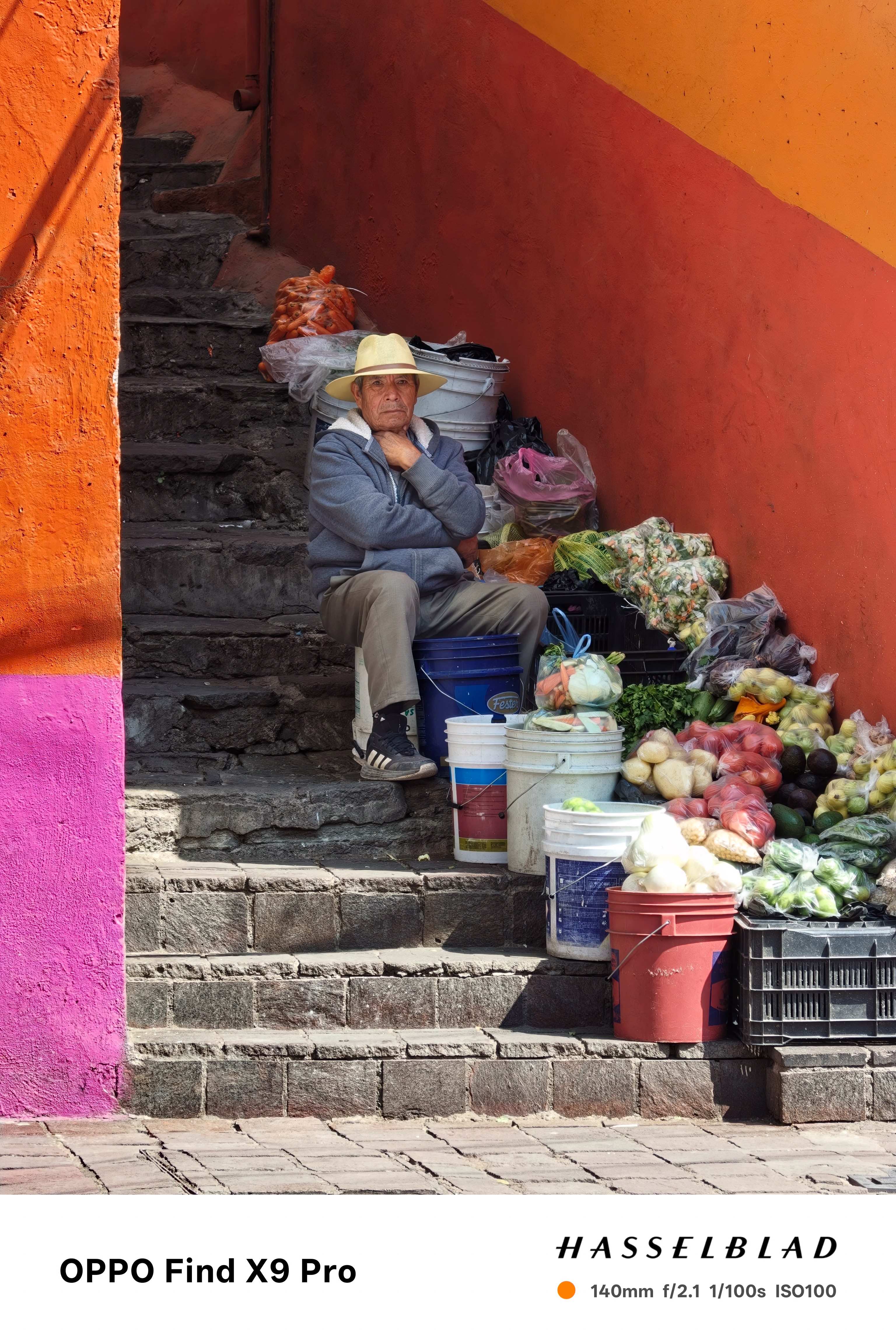 A man sits on a set of certain steps selling fruits and vegetables