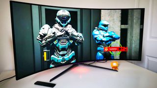LG UltraGear 45GR95QE-B with Halo Infinite Spartans on screen sitting on white desk