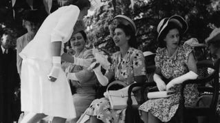 Rene du Preez, daughter of the Mayor of Ladybrand, presenting Princess Elizabeth with a bunch of flowers, seated with her mother Queen Elizabeth and sister Princess Margaret (right), in the Orange Free State, March 19th 1947.