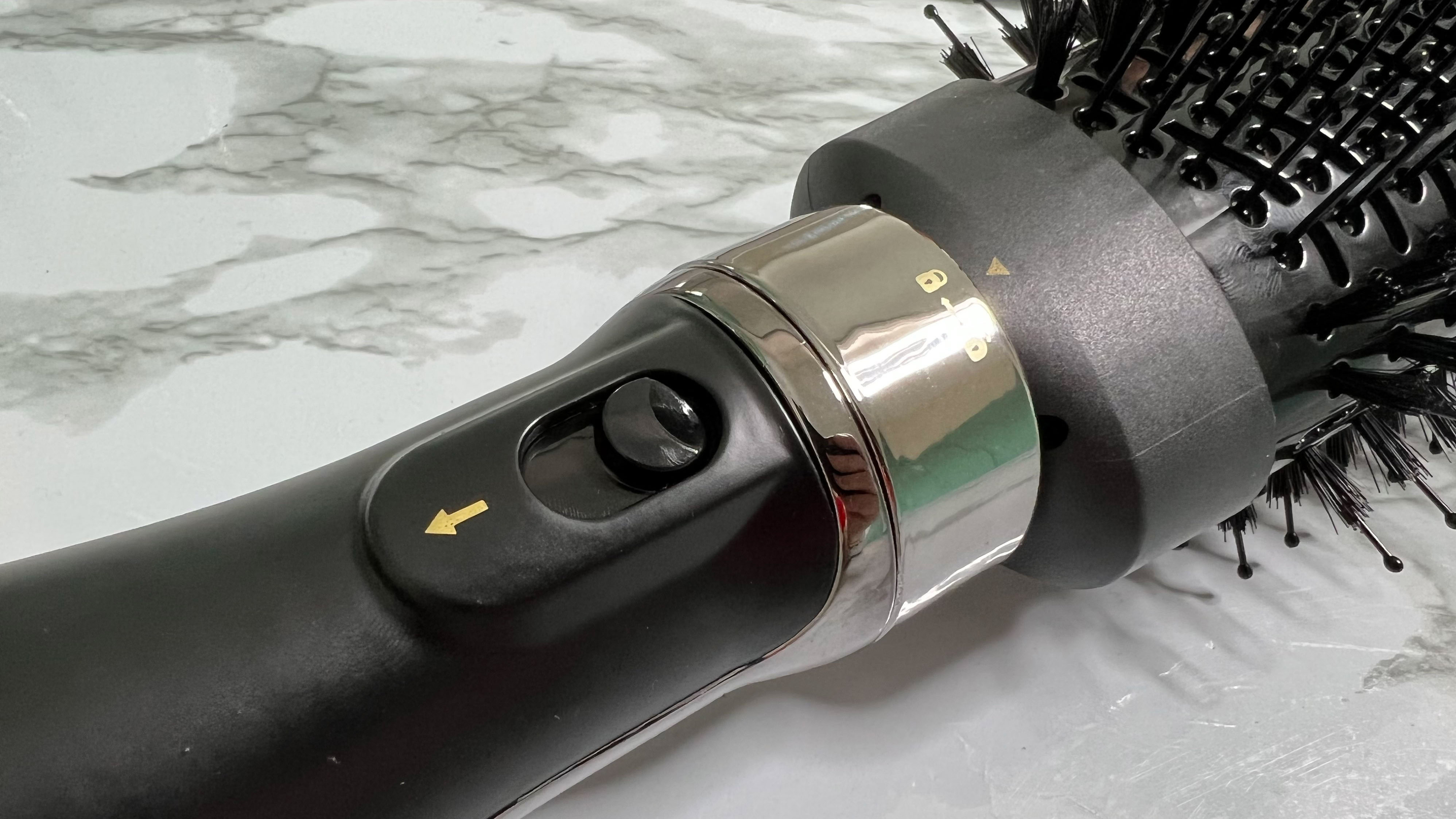 Tampilan close-up dari sakelar pengunci yang menahan attachment pada tempatnya di Hot Tools Volumiser 2-in-1 Brush and Dryer Set