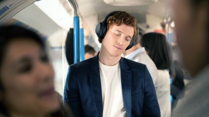 Best noise cancelling headphones 2022, man wearing headphones on a train