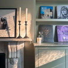 Close up of marble fireplace, mantlepiece and pale green built in shelving