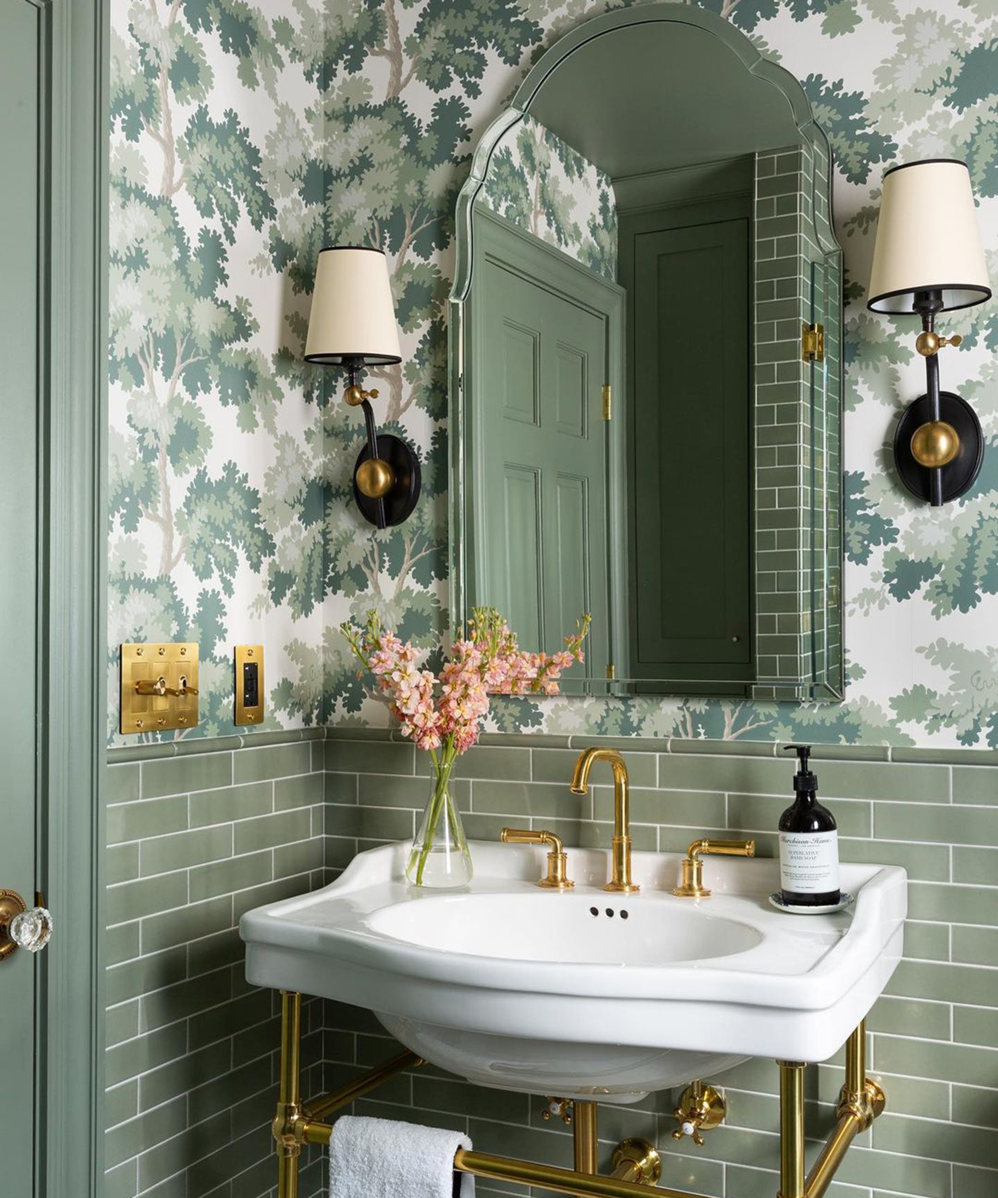 A small bathroom idea using Card Room Green Paint by Farrow & Ball, green metro tiles, mirror, printed green wallpaper, white basin and brass fixtures