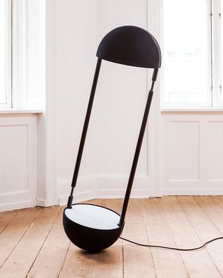 lamp balances on a half-sphere, emitting a soft glow