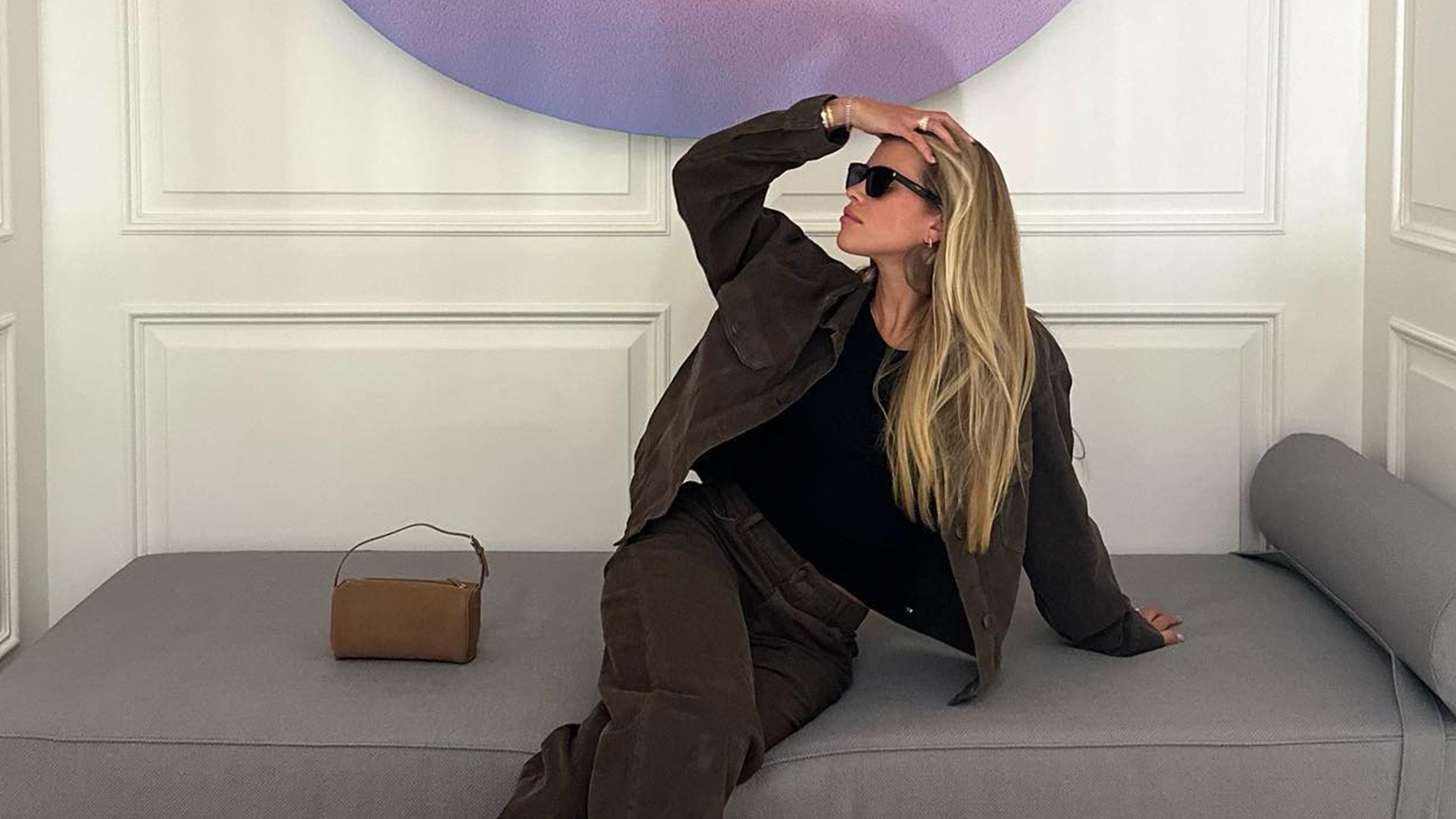 Sofia Richie Grainge sitting on a chaise lounge wearing a matching set with a The Row 90's bag.