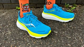 Person wearing the Saucony Hurricane 24 running shoe with vivid orange socks