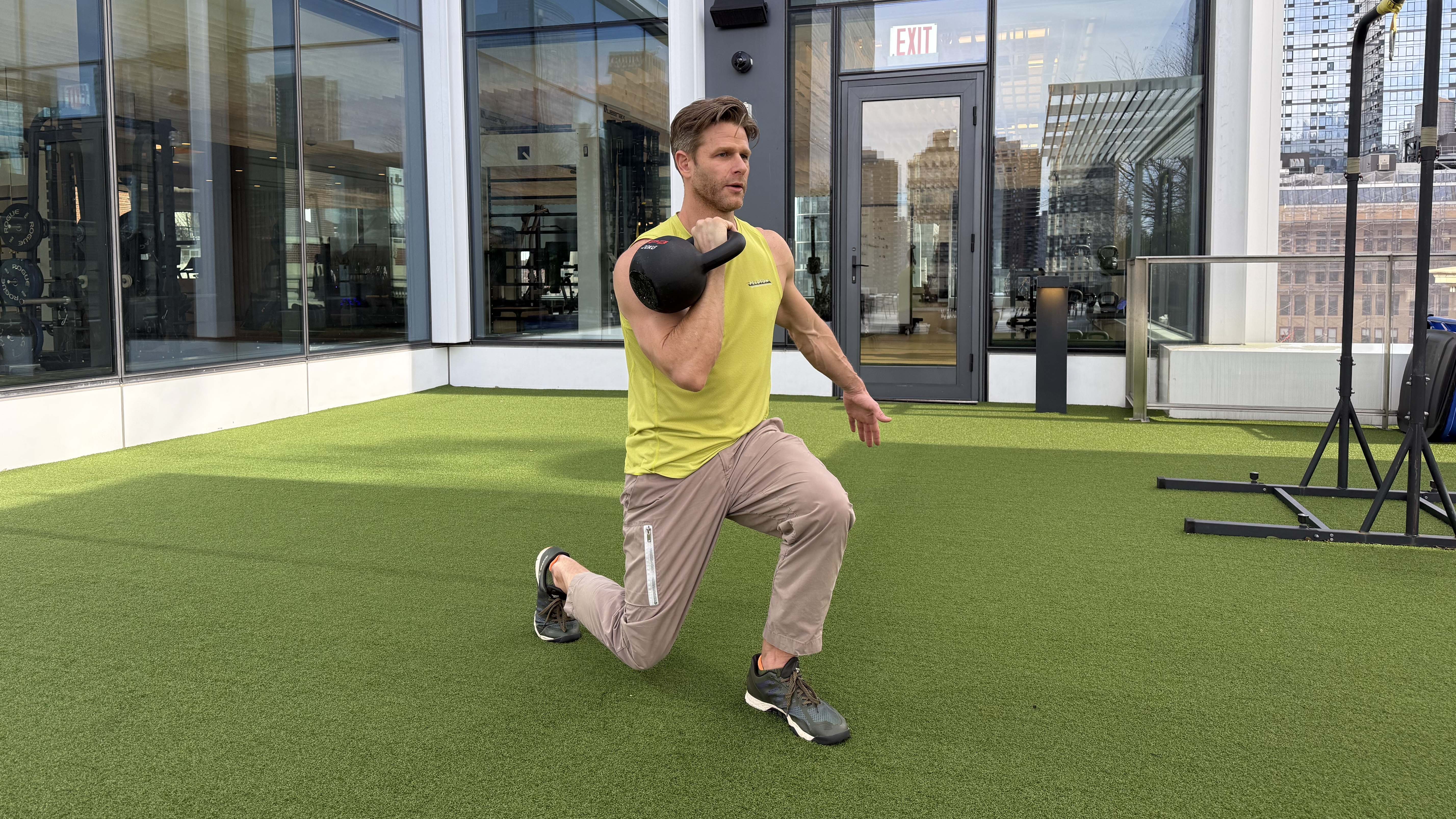 a photo of Peloton trainer Andy Speer doing a kettlebell single-arm racked lunge