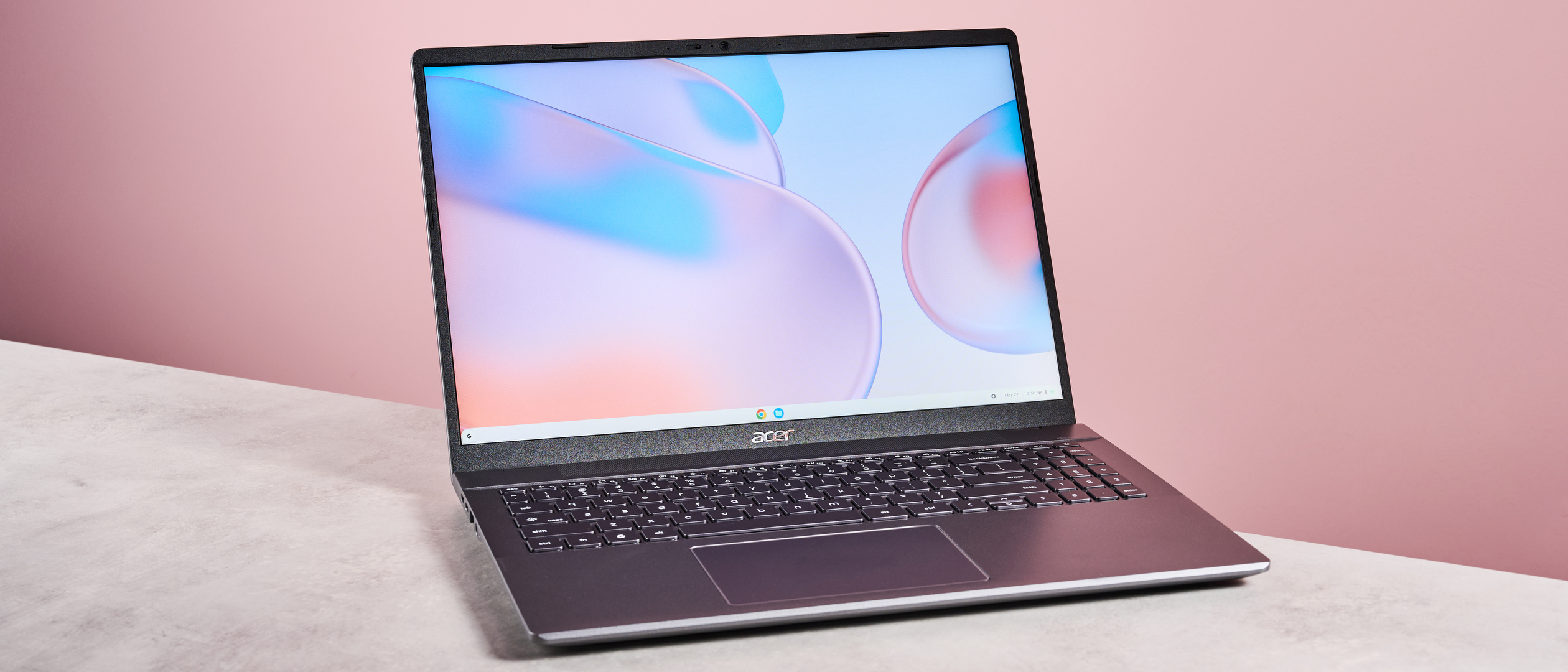 Acer Chromebook Plus 514 open on desk with pink background
