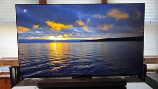 LG C3 OLED TV met een beeld van een zonsondergang aan het water op het scherm