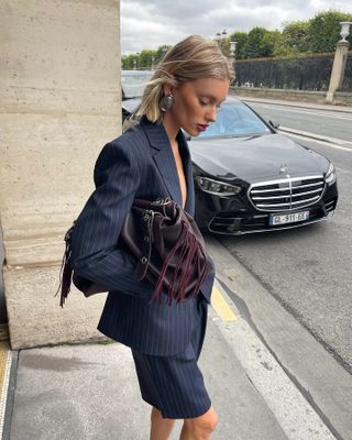 Elsa Hosk wearing a pinstripe skirt suit