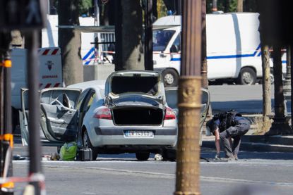 Bomb disposal police officer checking car.