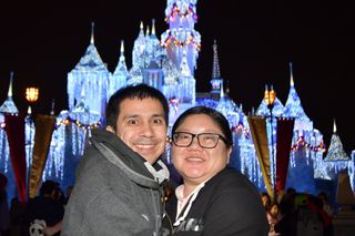 Christine and Robert in front of holiday Sleeping Beauty's Castle at Disneyland
