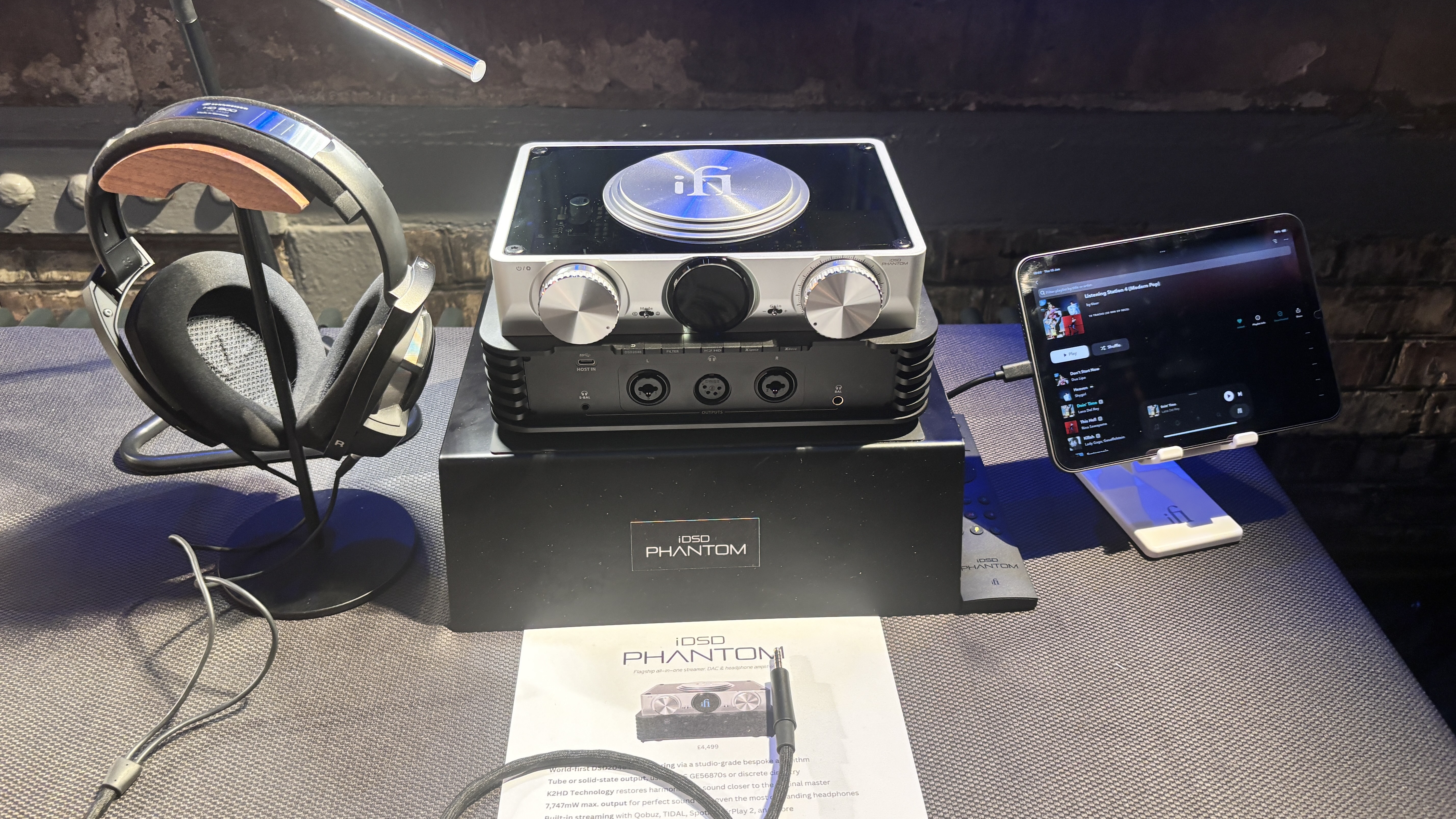 iFi Phantom music streamer flanked by a pair of headphones and an iPad