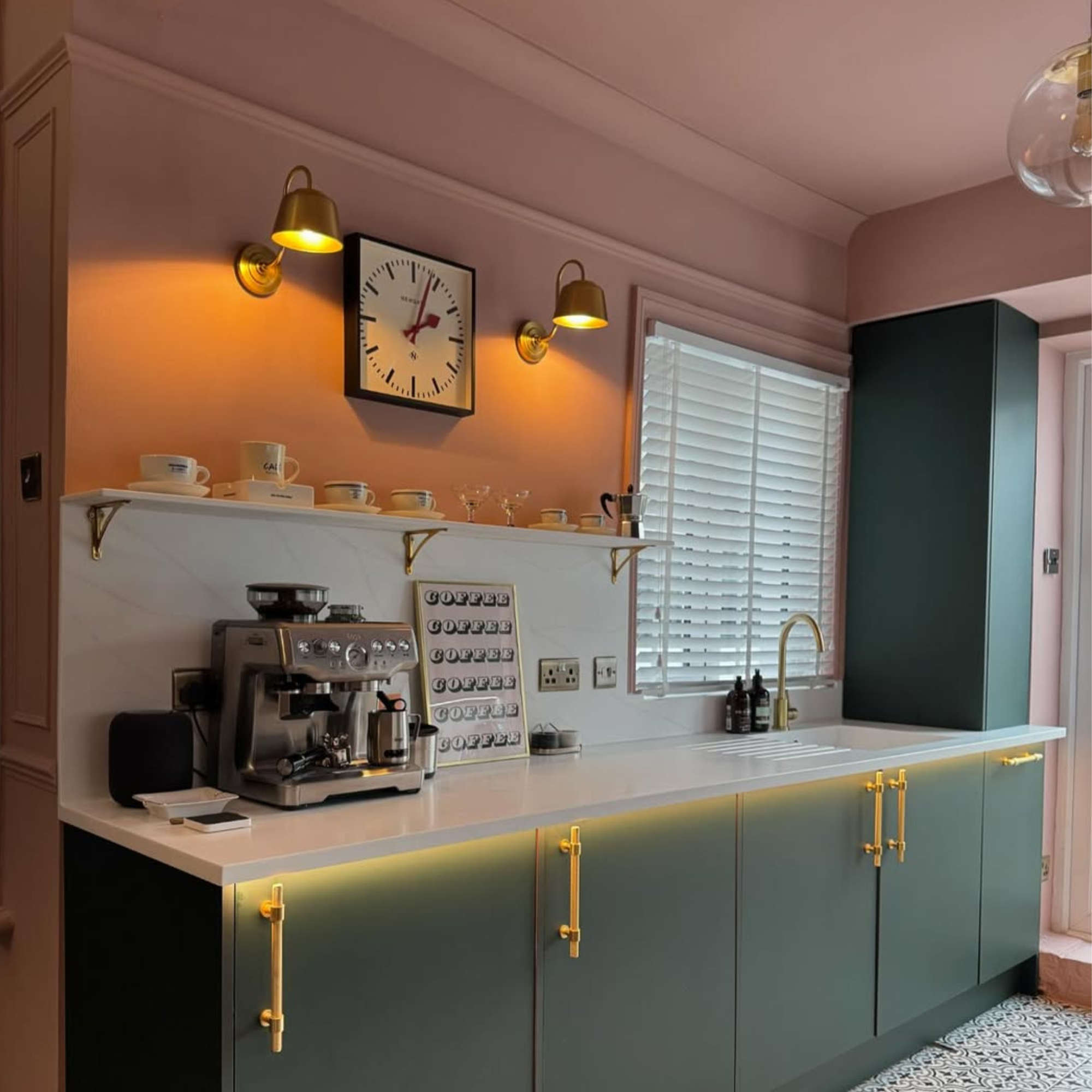 a pink painted kitchen with green cabinets and tiled flooring