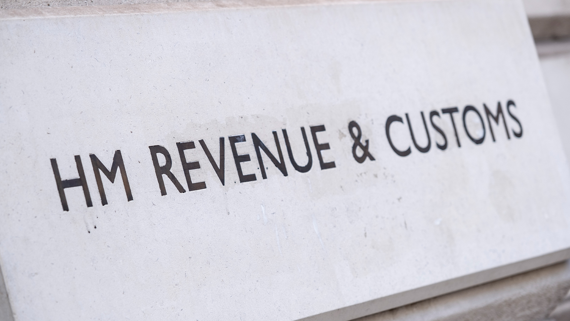 His Majesty's Revenue and Customs (HMRC) sign engraved in stone in Whitehall, London.