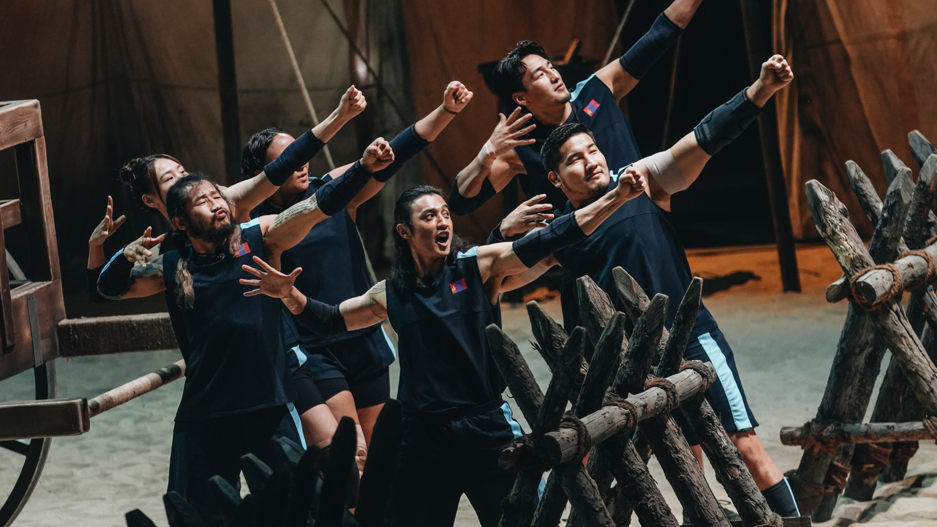 Six athletes from Team Mongolia (l-r Khandsuren Gantogtokh, Enkh-Orgil Baatarkhuu, Adiyasuren Amarsaikhan, Lkhagva-Ochir Erdene-Ochir, Dulguun Enkhbat, Orkhonbayar Bayarsaikhan) make a pose of holding a bow and arrow, in Netflix&#039;s &#039;Physical: Asia&#039;.