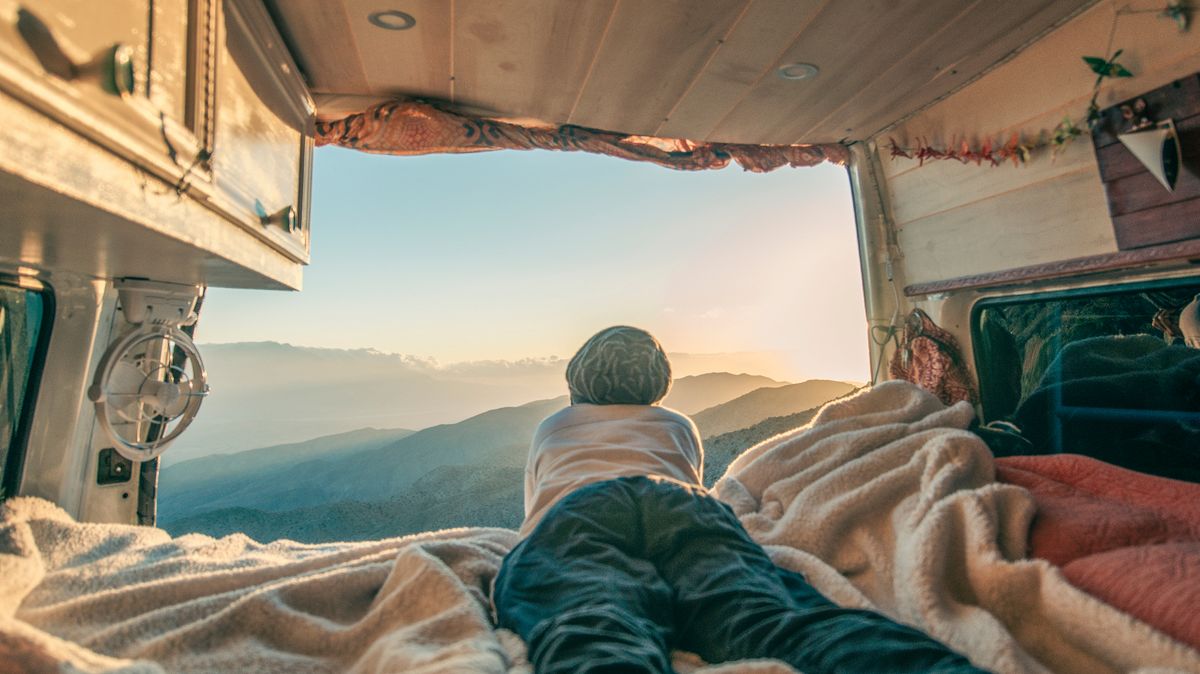 A camper looking out of a camper van window