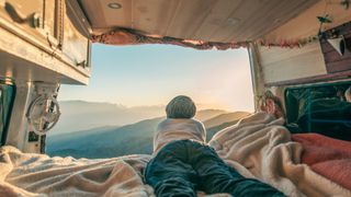 A camper looking out of a camper van window