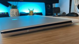 Alienware X16 R2 gaming laptop closed on a wooden desk with blue lighting