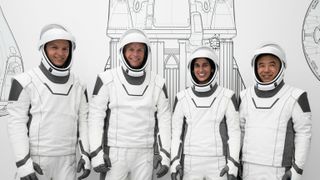 four astronauts dressed in spacex's black-and-white spacesuits pose at the company's california headquarters during a training session