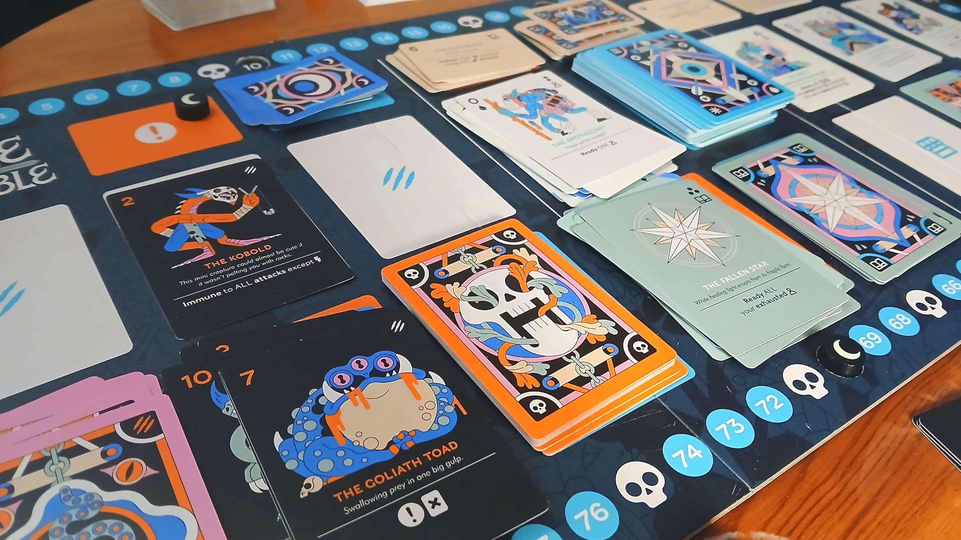 Fame &amp;amp; Fable board with cards across it, laid out on a wooden table