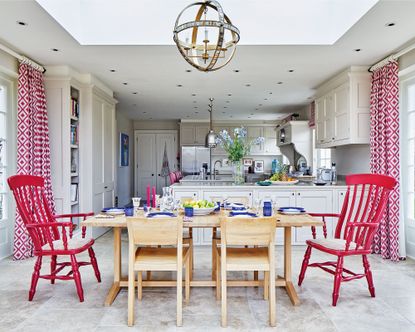 Red kitchen ideas in a pale gray scheme with red patterned drapes and chairs.