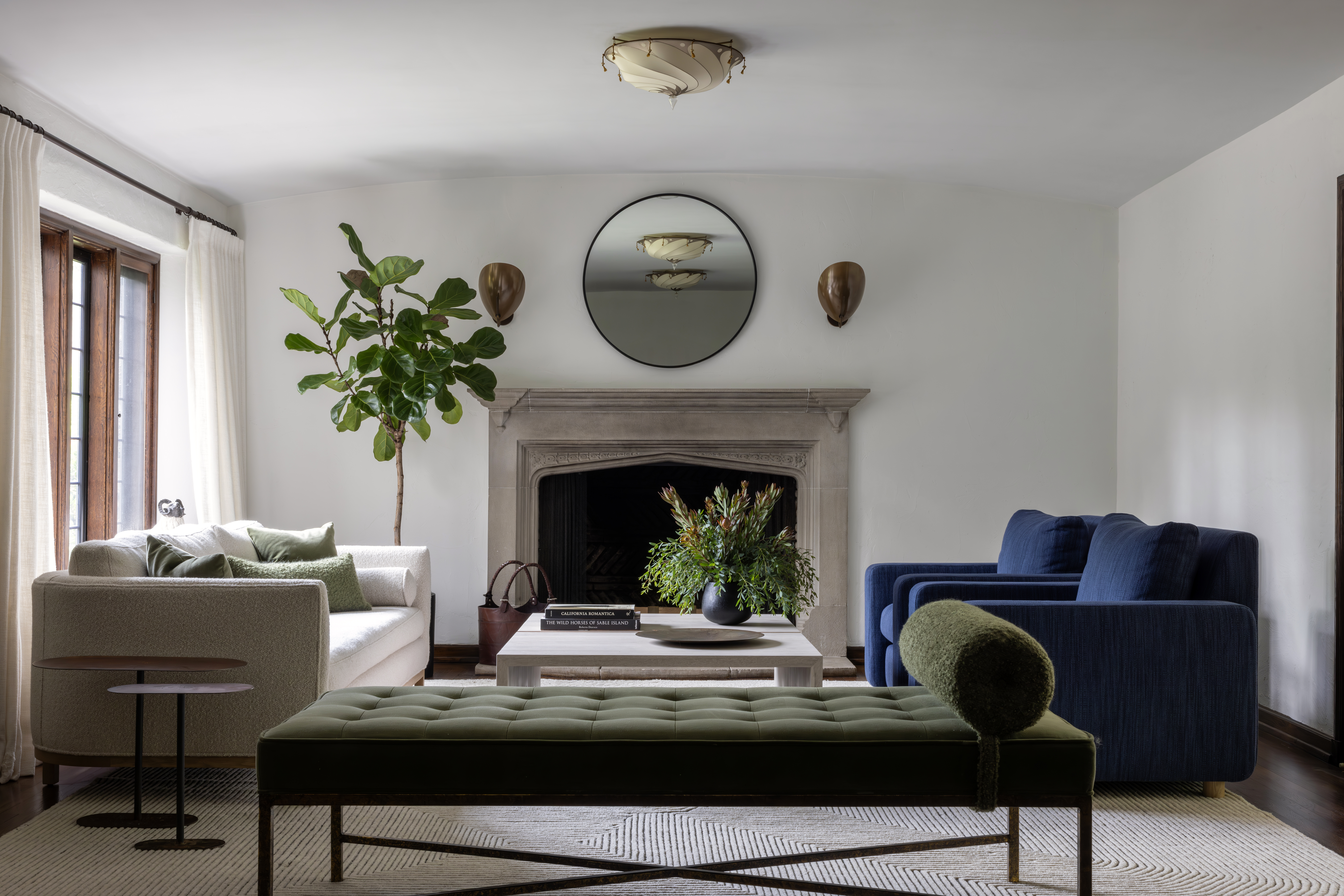 A gorgeous modern living room with a white couch and a blue couch, plus a green daybed in the foreground.
