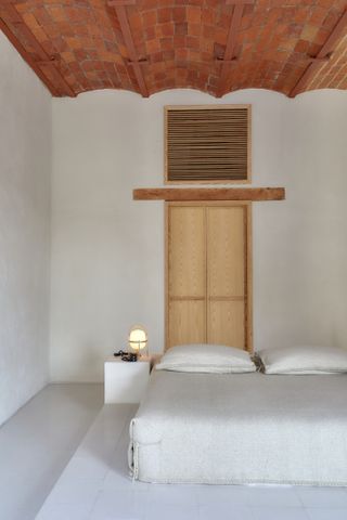 A bedroom with brick tiles on the ceiling