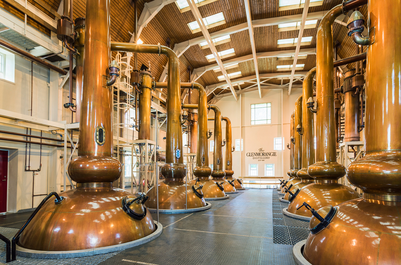 Rows of copper stills inside a whisky distillery