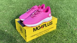 G/Fore Women’s MG4+ Golf Shoes with yellow shoe box lying on grass