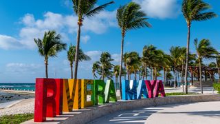 A colorful sign that spells out Riviera Maya on a beach in Mexico