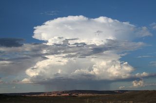 A cloud dumps rain in the desert.