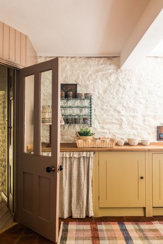 country style cabinetry in yellow, with curtain