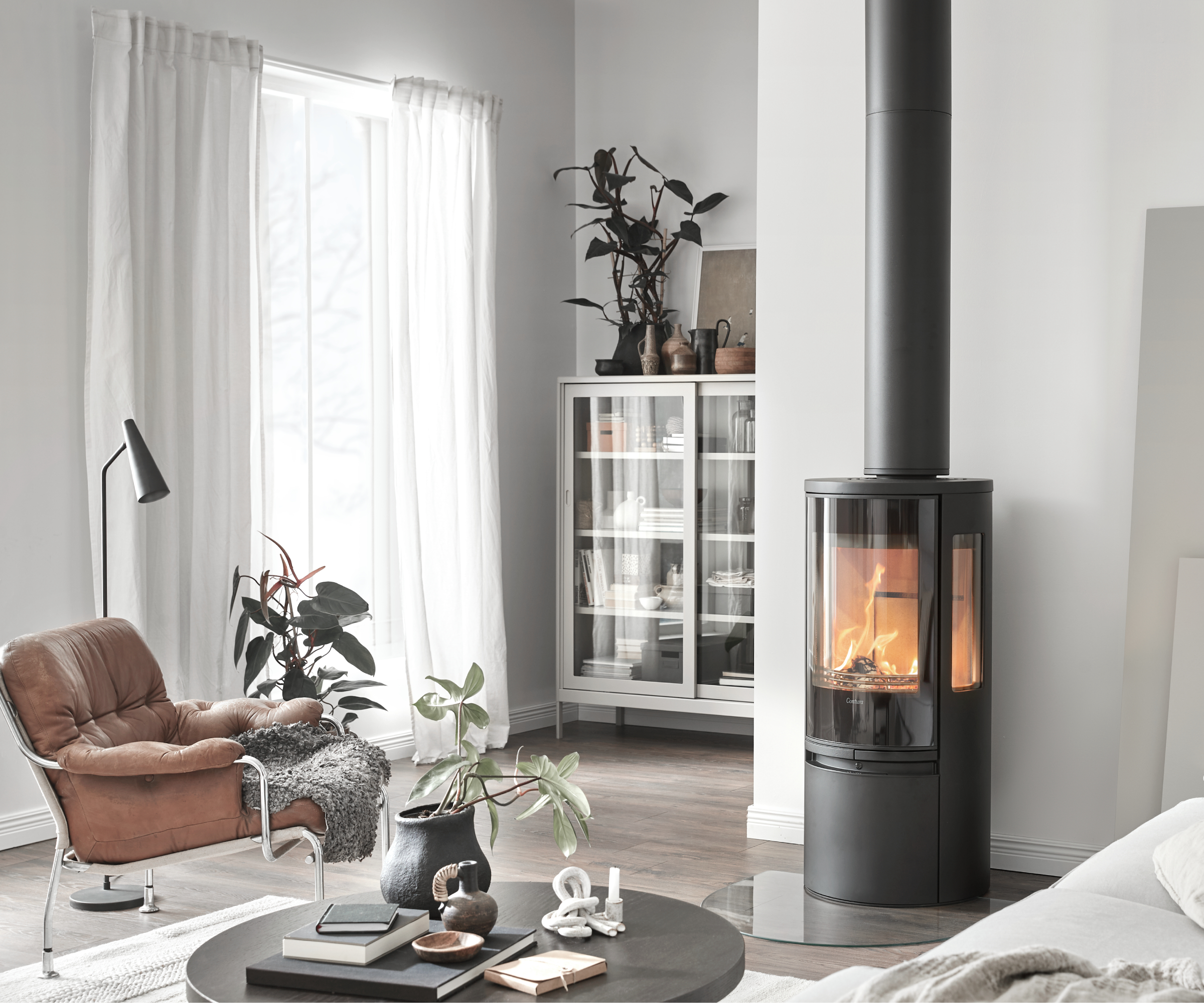 log burner in living room with wooden floor, white walls and seating