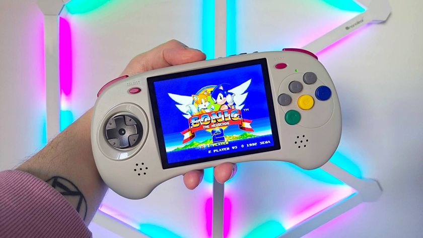 Hand holding Anbernic RG ARC-D handheld with Sonic the Hedgehog 2 gameplay on screen