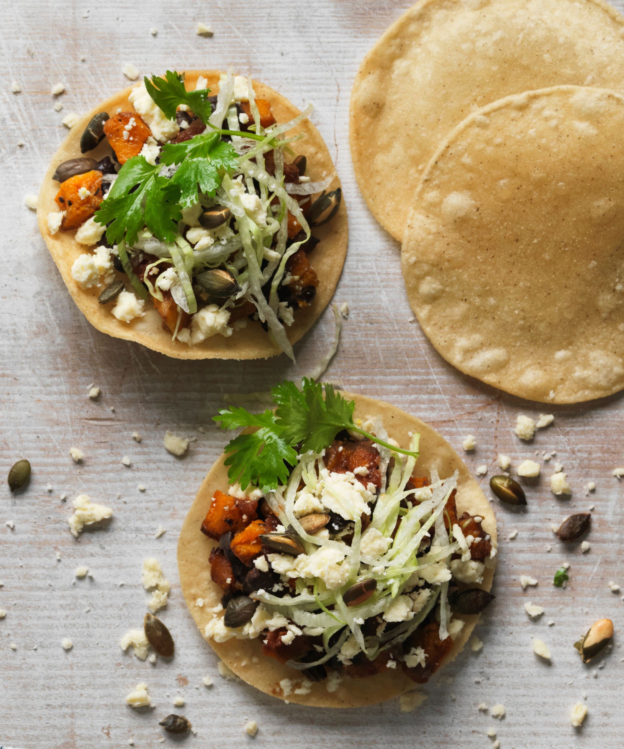 Black bean tostadas with cilantro and pumpkin seeds scattered over them