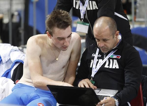 Elia Viviani consults with Italian coach Marco Velo on his omnium strategy